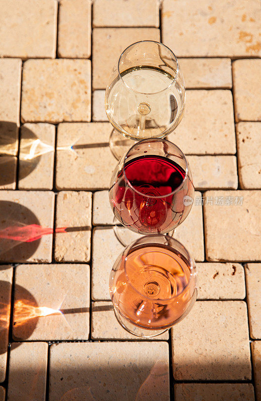 Wine glass variety with red, white and rosé wine at vineyard wine tasting in sunlight